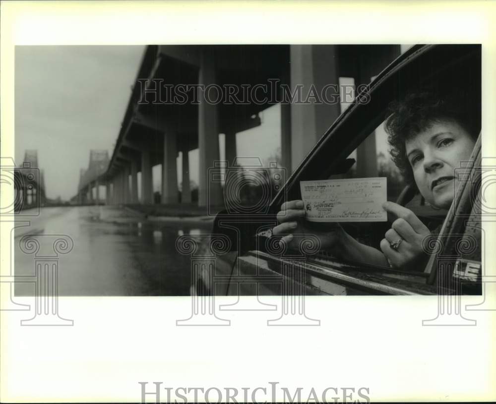 1995 Press Photo Katie Rayhawk holds check to pay highway toll in Louisiana - Historic Images