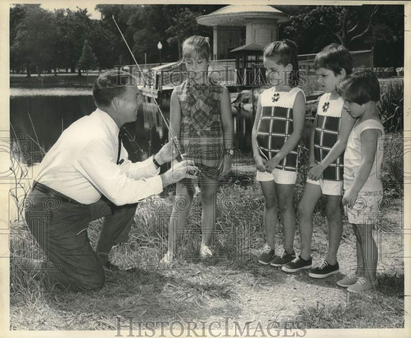 Load image into Gallery viewer, 1969 Press Photo Merlin Remmers Prepares Children for Kid Fishing Rodeo

