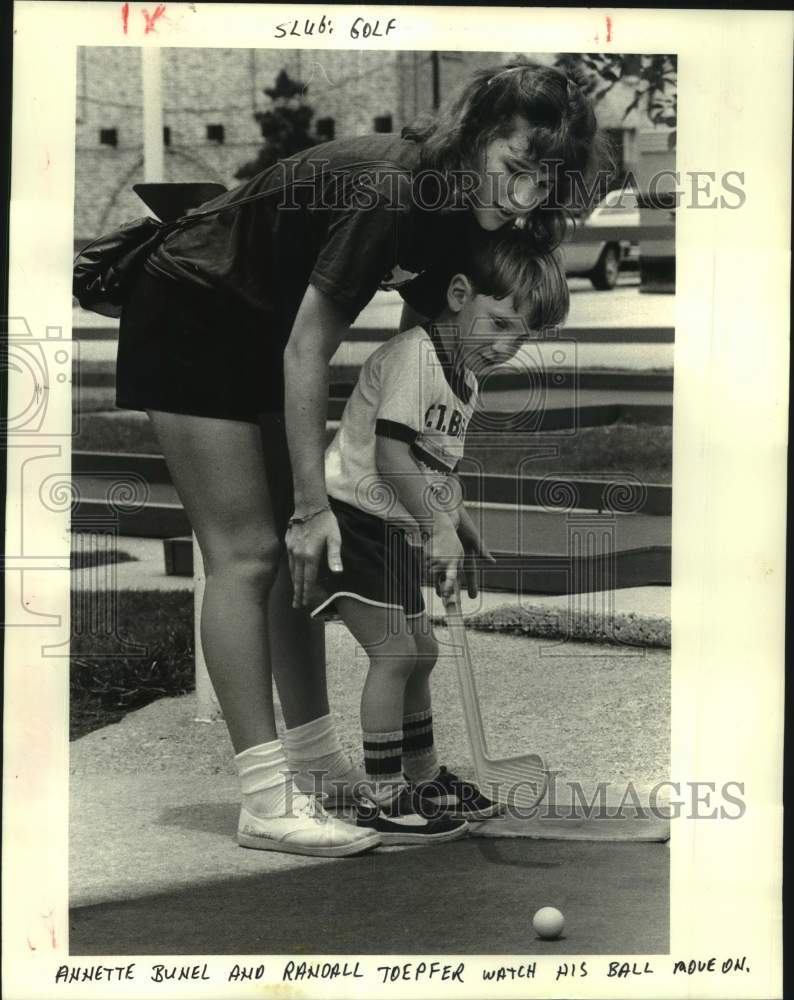 1985 Press Photo Annette Bunel Helps Little Randall Toepper at Putt-Putt Golf- Historic Images