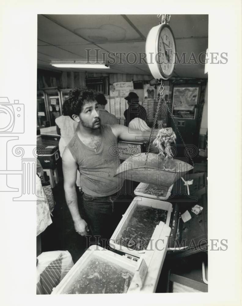 Load image into Gallery viewer, 1988 Press Photo King Roger's Fishmarket employee Ronald Aiola weighs shrimp.
