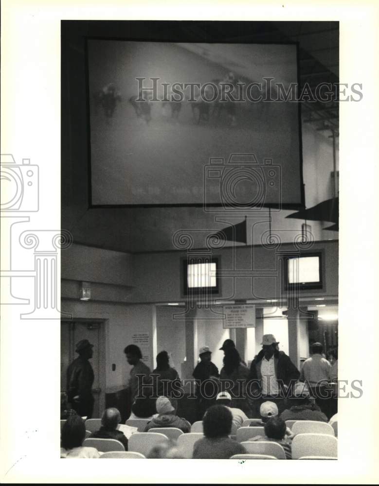 1990 Press Photo Gretna Race Track Handicappers Watch Race on Large Screen TV- Historic Images