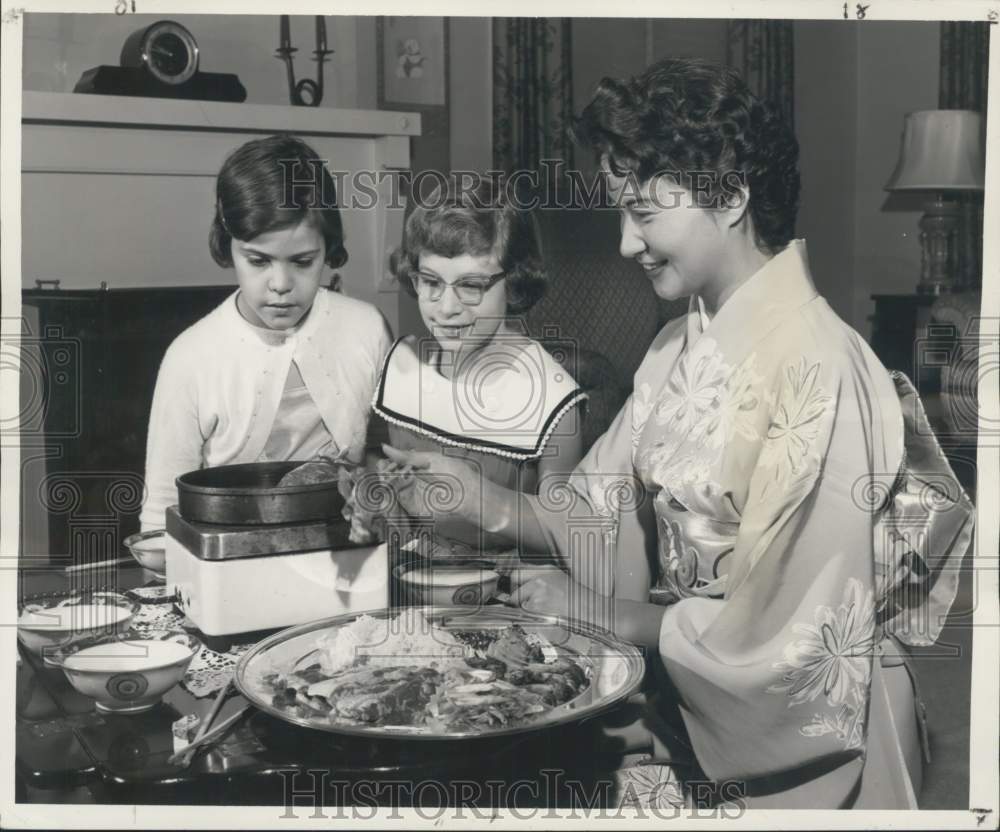 1957 Press Photo Mrs. Nissi Sato shows children how to prepare sukiyaki