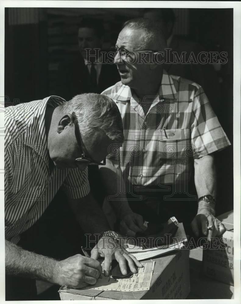 Load image into Gallery viewer, 1969 Press Photo Gen. Raymond F. Hufft accepts Al Petitfils cases of canned food
