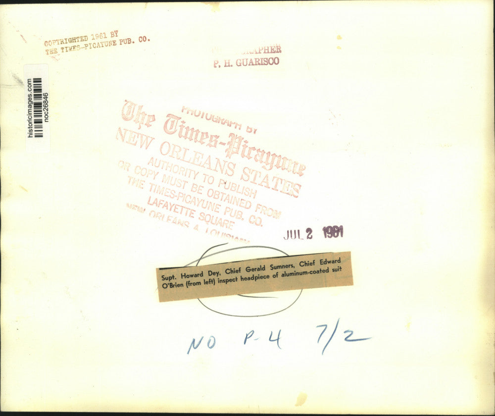 1961 Press Photo New Orleans Fire Department officials inspect suit headpiece