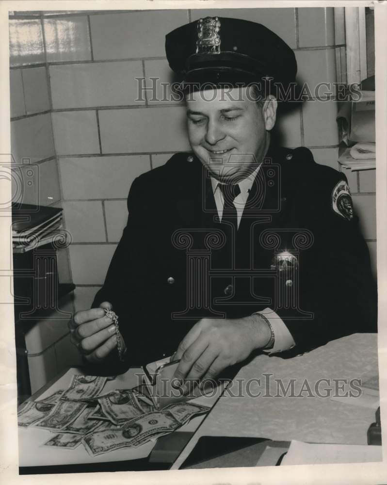Load image into Gallery viewer, 1961 Press Photo Patrolman Louis Schick Jr. with recovered stolen merchandise
