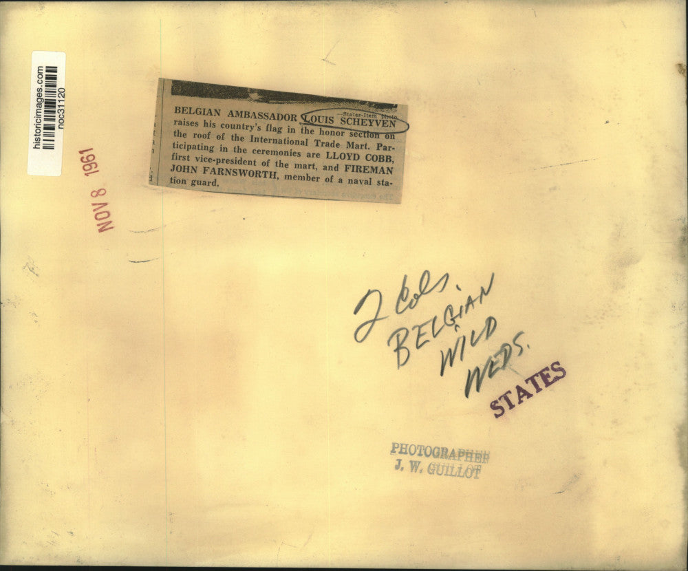 1961 Press Photo Belgian Ambassador Louis Scheyven Raises Flag, Trade Mart Roof