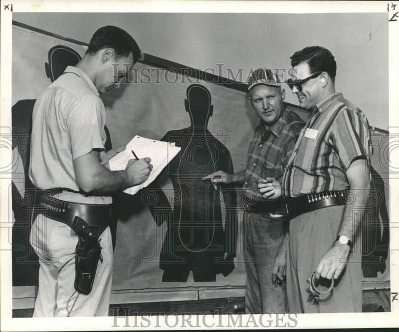Load image into Gallery viewer, 1958 Press Photo Patrolman Arthur Arnold checks Nick Macheca's Shooting Score
