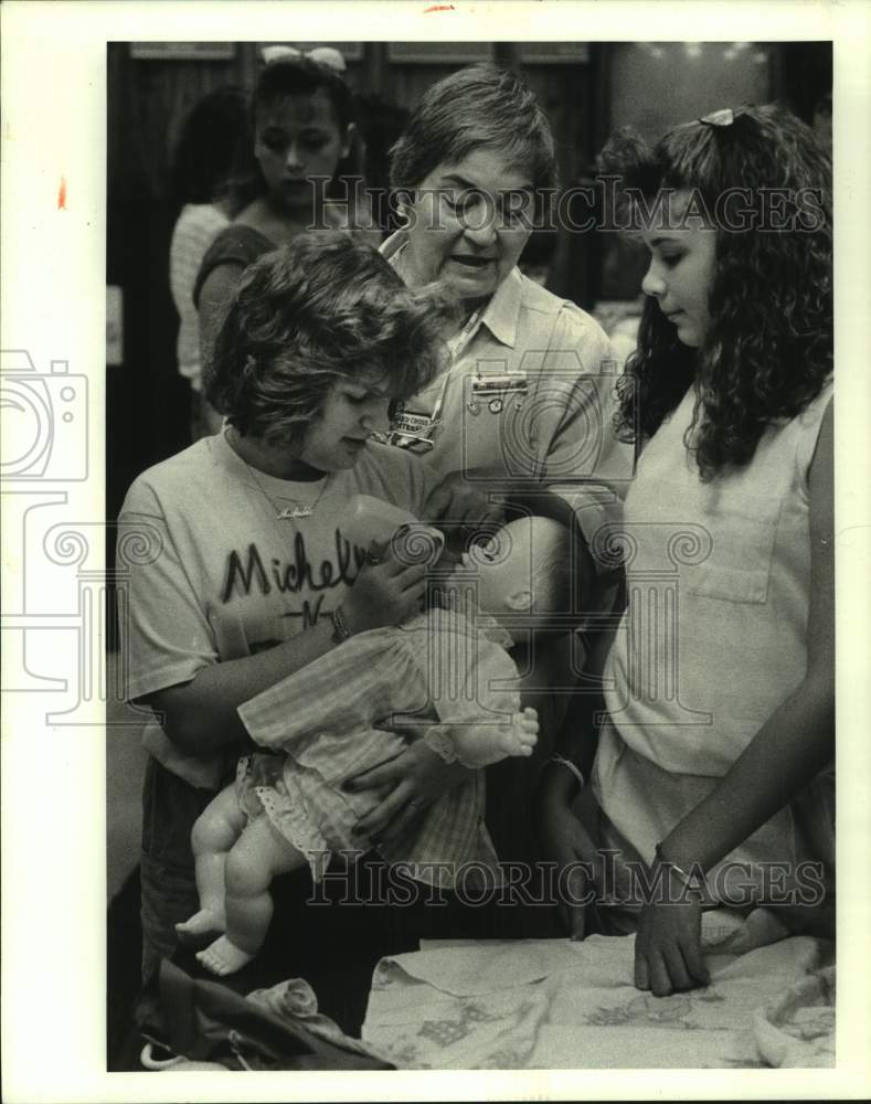 1988 Press Photo Red Cross Volunteer Bea Touchard teaches Students to Feed Baby- Historic Images