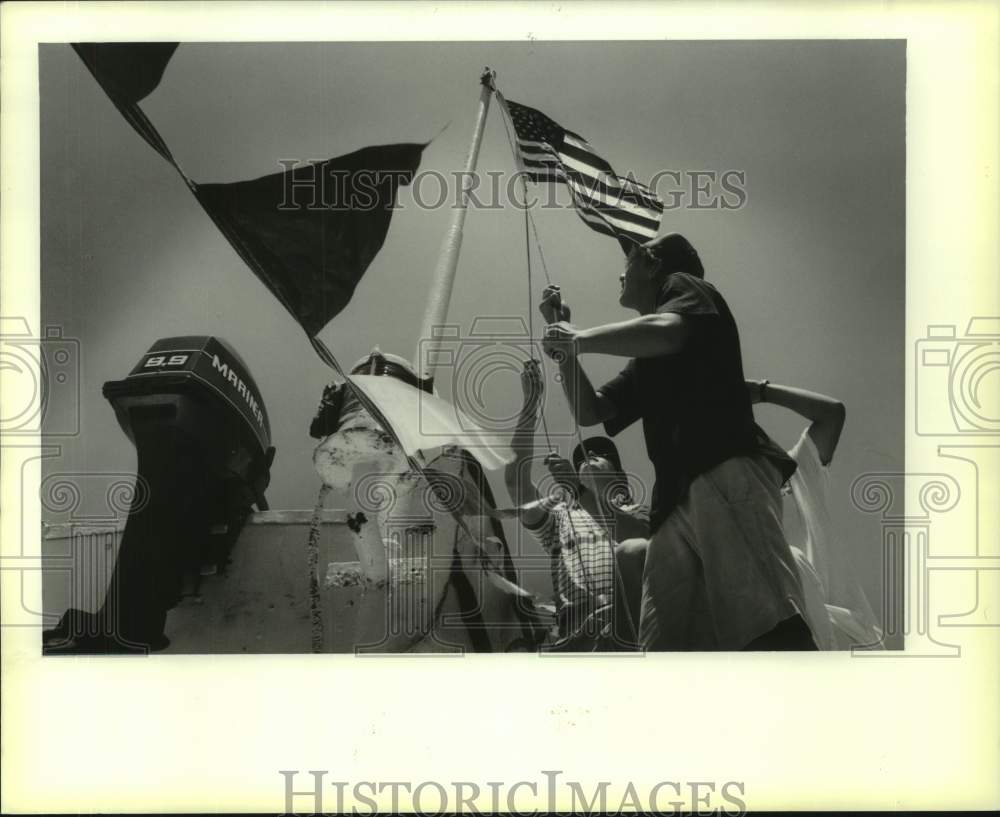 1988 Press Photo Jack Abney raises American flag aboard Sea Explorer - noc38663- Historic Images