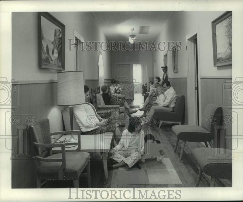 Load image into Gallery viewer, 1969 Press Photo Adults and Children Relax, Read &amp; Play In Communal Hallway
