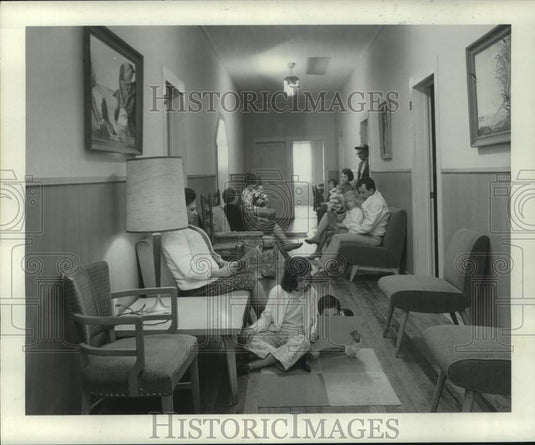 1969 Press Photo Adults and Children Relax, Read & Play In Communal Hallway