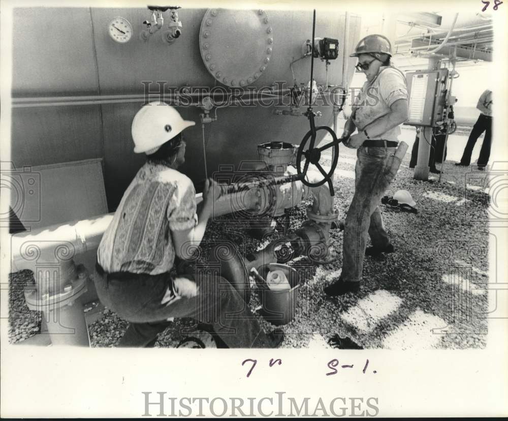 1976 Press Photo Jackie Adlridge lubricates gear box in oil field - noc41594