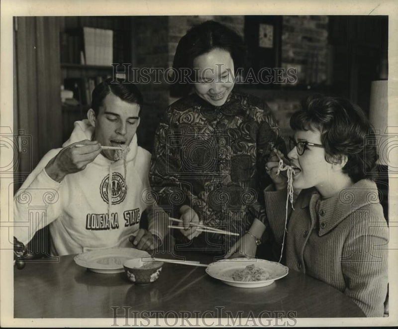 Load image into Gallery viewer, 1963 Press Photo Stella Wu serves traditional chow mein to friends - noc42808
