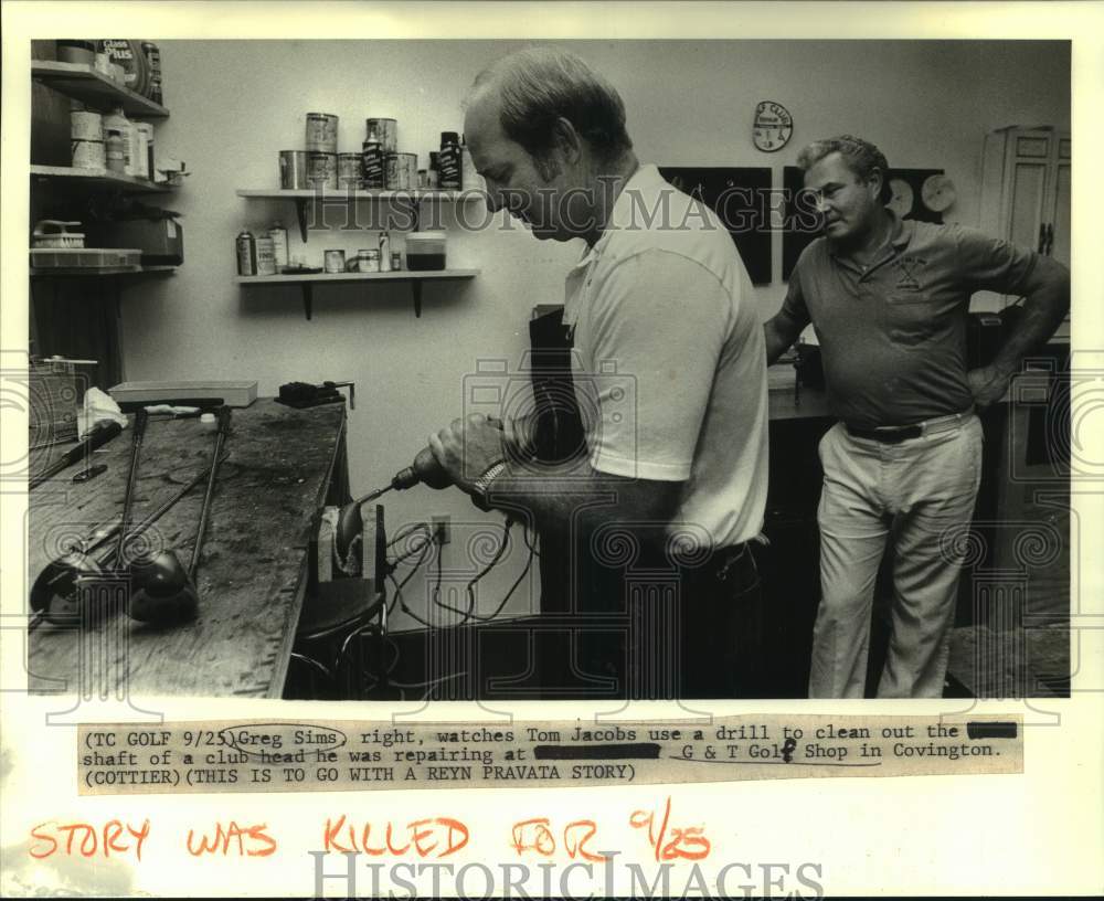 1988 Press Photo Greg Sims watches Tom Jacobs clean golf club at G&T Golf Shop- Historic Images