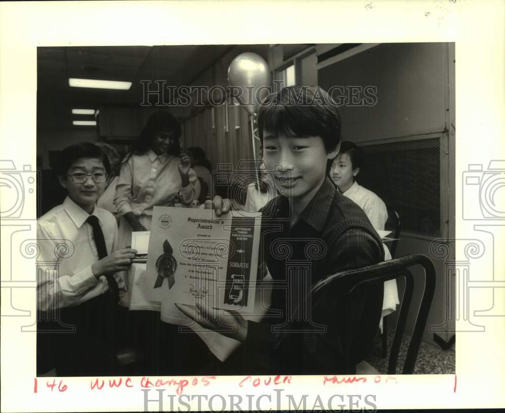 1987 Press Photo Eun Suk Yoon shows his straight-A award.- Historic Images