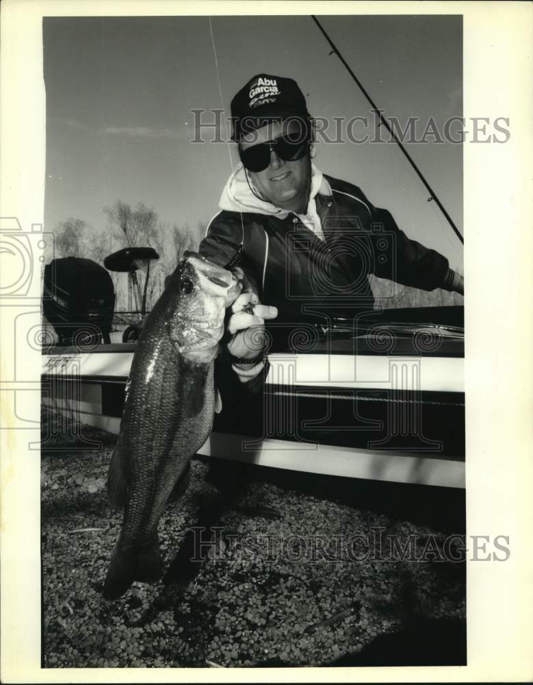 Press Photo Fisherman proudly displaying his bass on his Venture Sports trip.- Historic Images