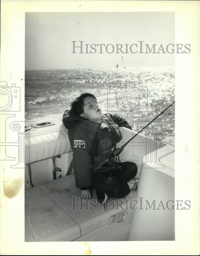 Press Photo Venture Sports-Young fisherman taking a snooze in a boat - noc51026- Historic Images