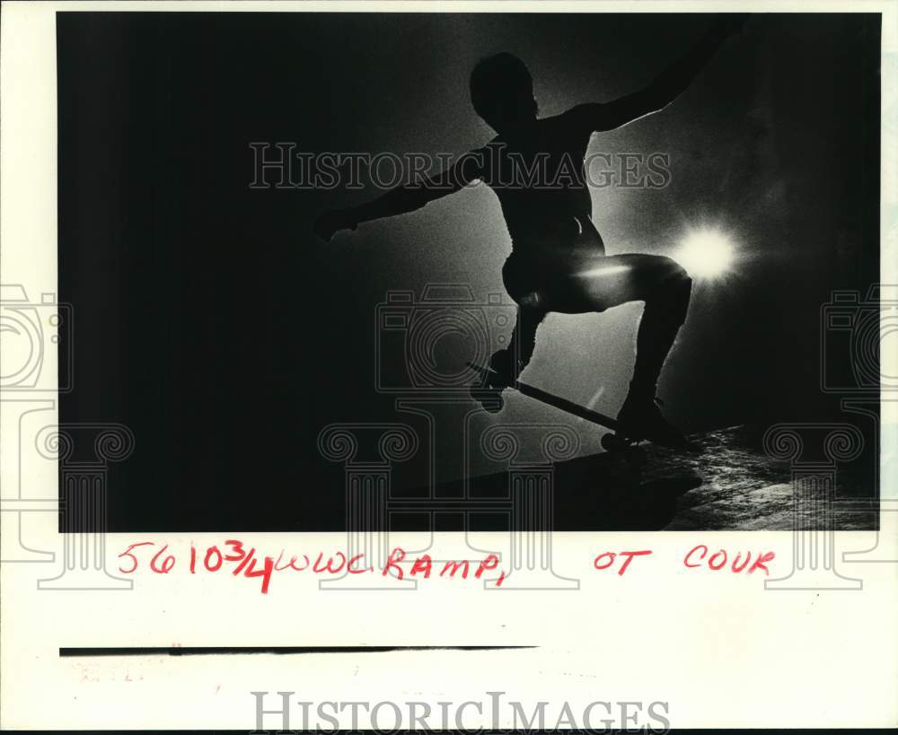 1985 Press Photo Abundance Street resident in Silhouette riding Skateboard- Historic Images