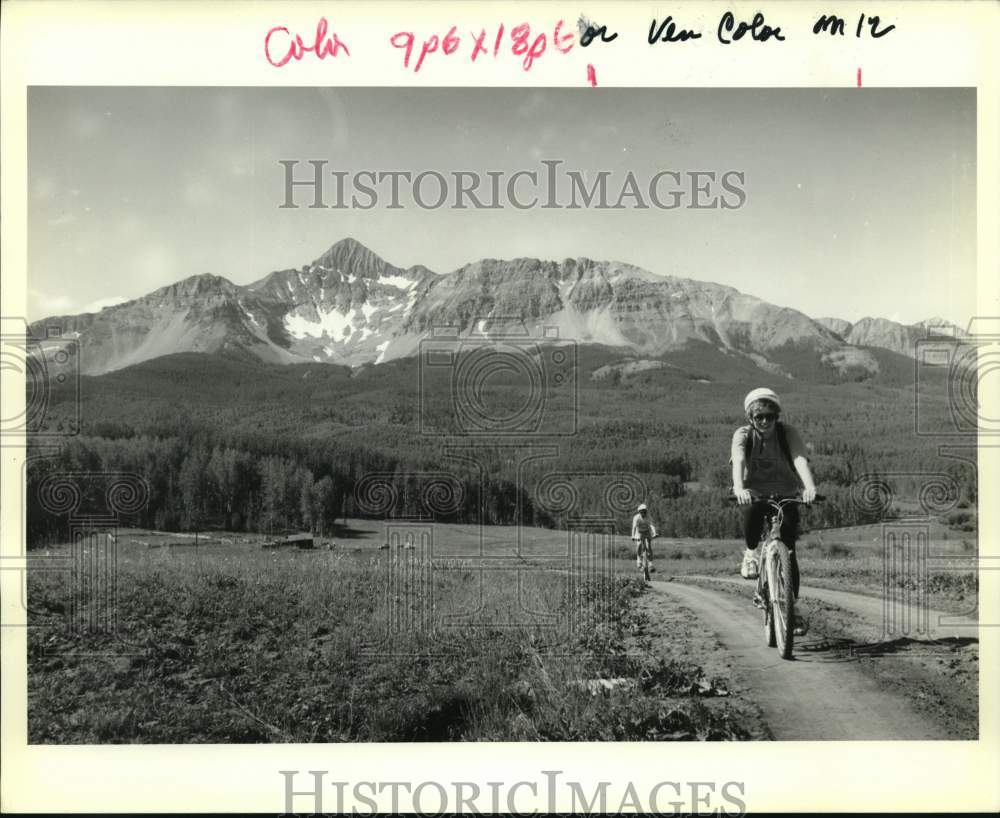 Press Photo Two Bike Riders with Mountain in Background - noc51129- Historic Images