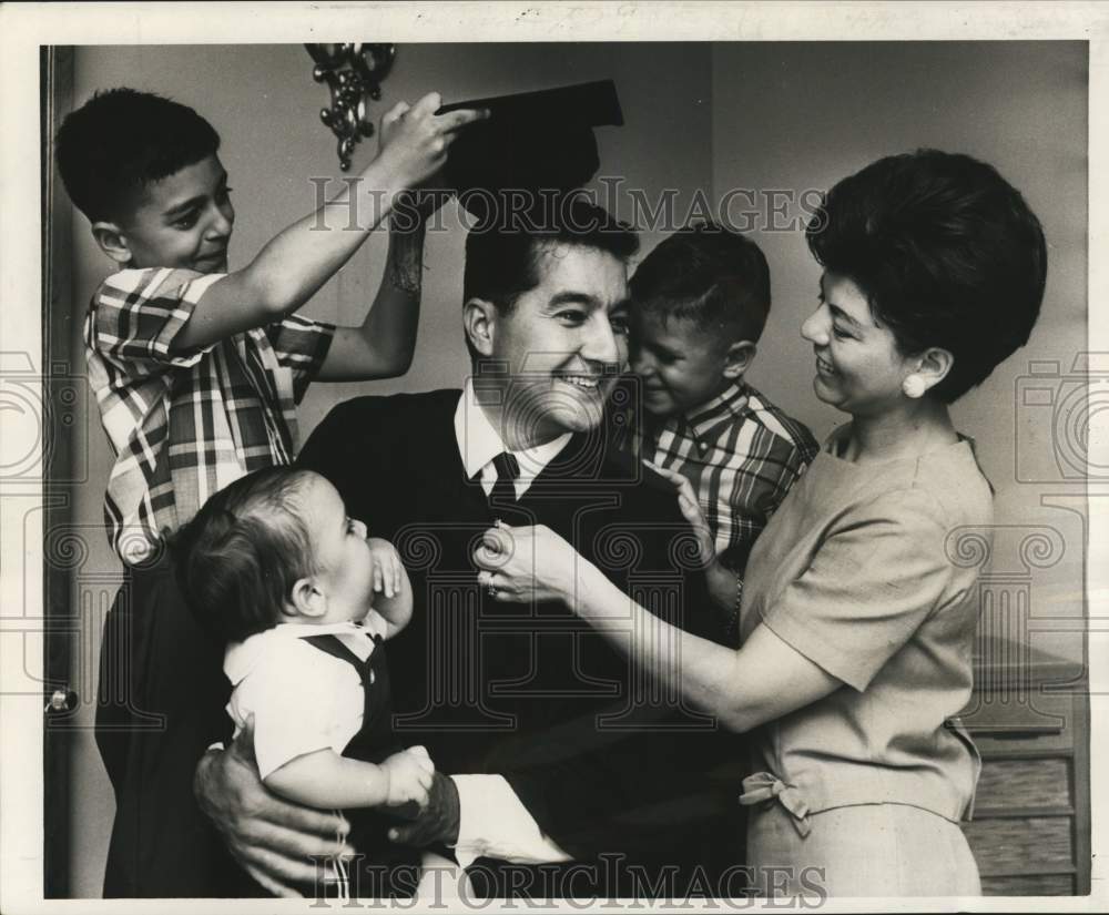 1966 Press Photo Frank Volpi tries on his graduation cap and gown for size.- Historic Images