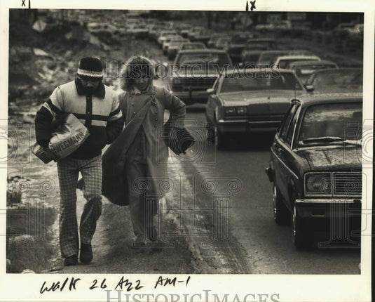 1985 Press Photo Couple walk busy road during wet cold weather - noc52809