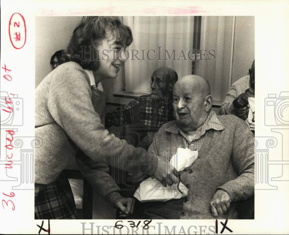 1985 Press Photo Kacie Wolf, hands William McConnell his gift bag at Waldon.- Historic Images