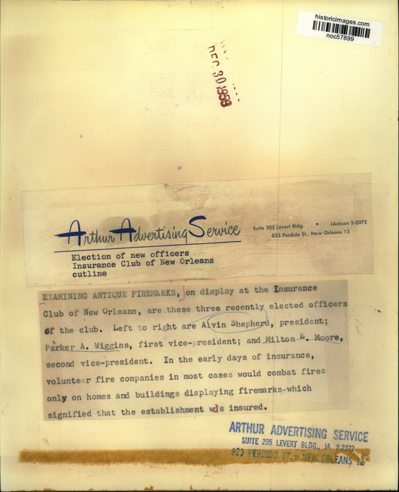 1959 Press Photo Examining Antique Firemarks on display at the Insurance Club