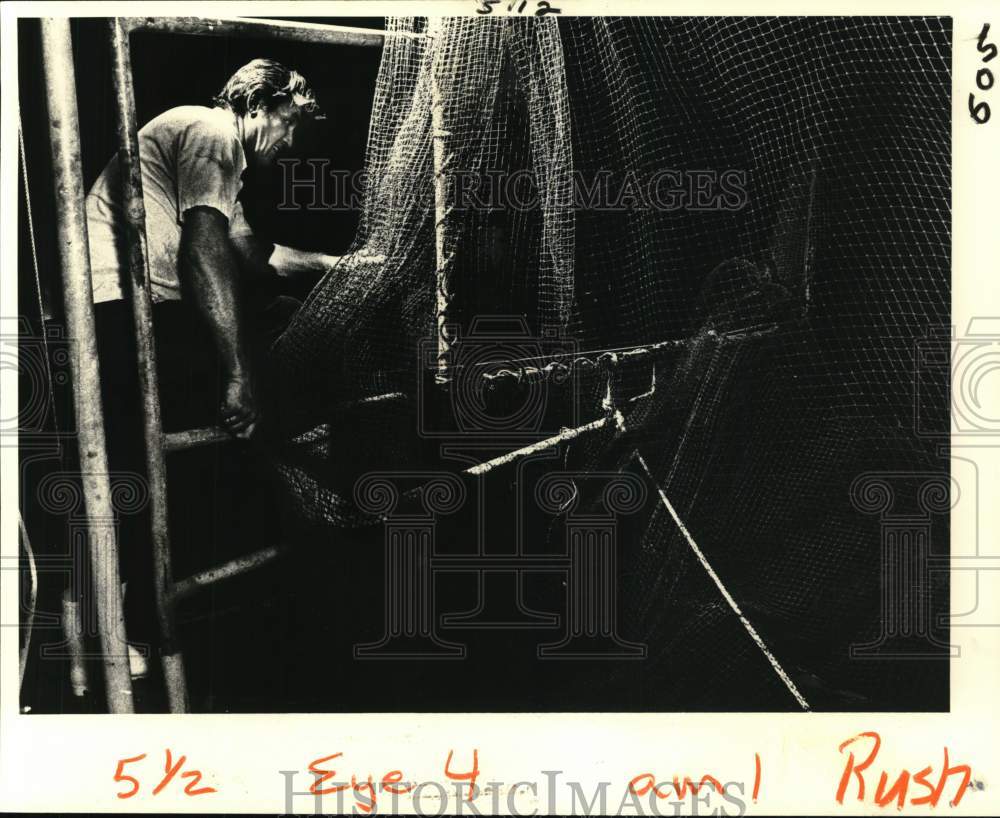 1981 Press Photo Knecht works in the darkness to clear tangled nets- Shrimping- Historic Images