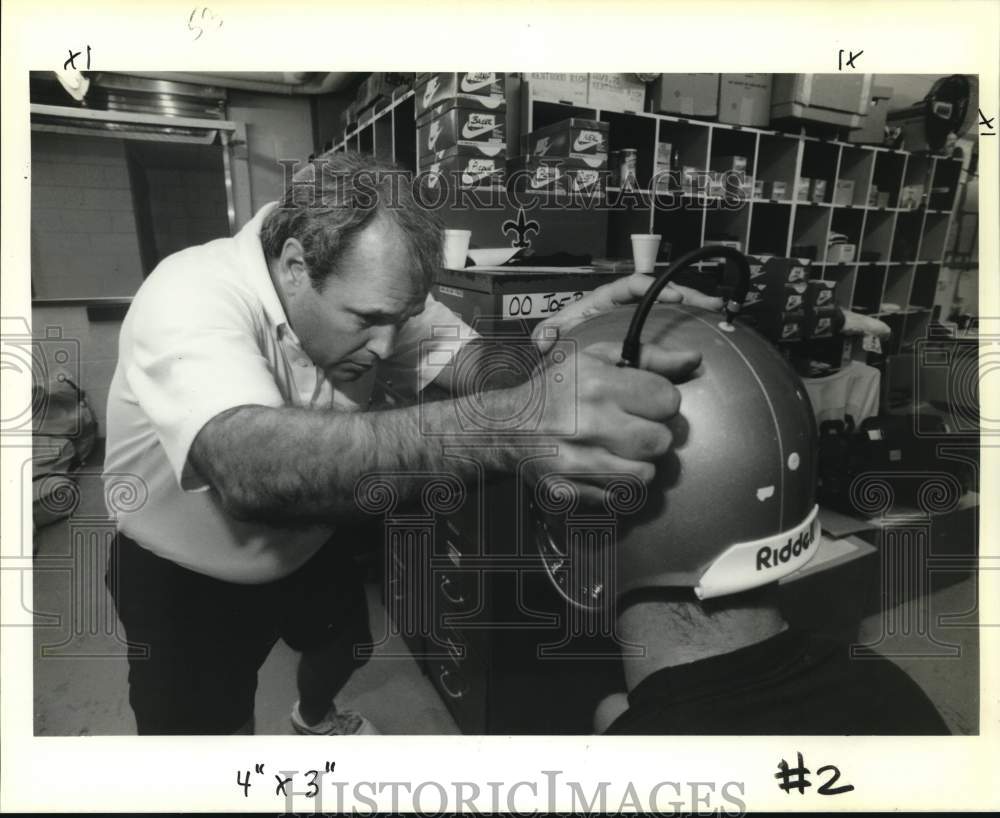 1989 Press Photo Football coach Curtis Simmons helps player with head gear- Historic Images