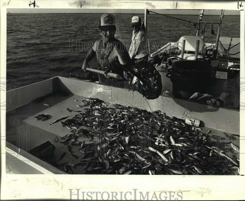 1984 Press Photo Barry Bordeleon sorts shrimp on his skiff as Willie Hof watches- Historic Images