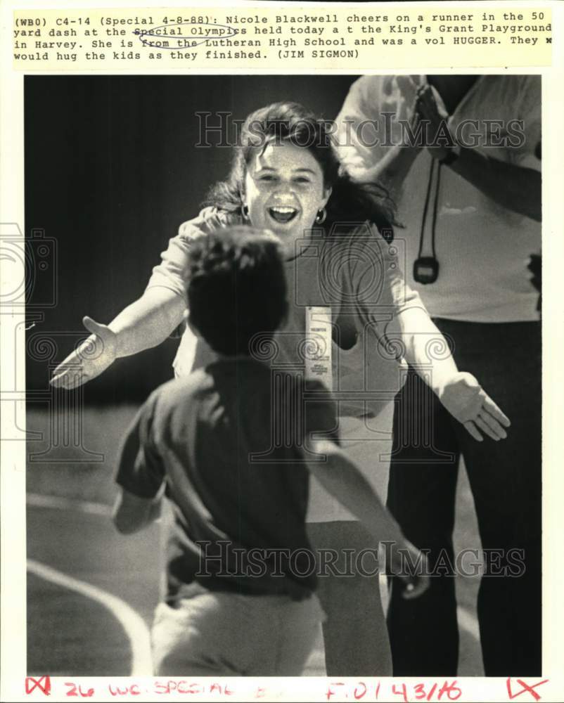 1988 Press Photo Volunteer Nicole Blackwell cheers on Special Olympics runner.- Historic Images