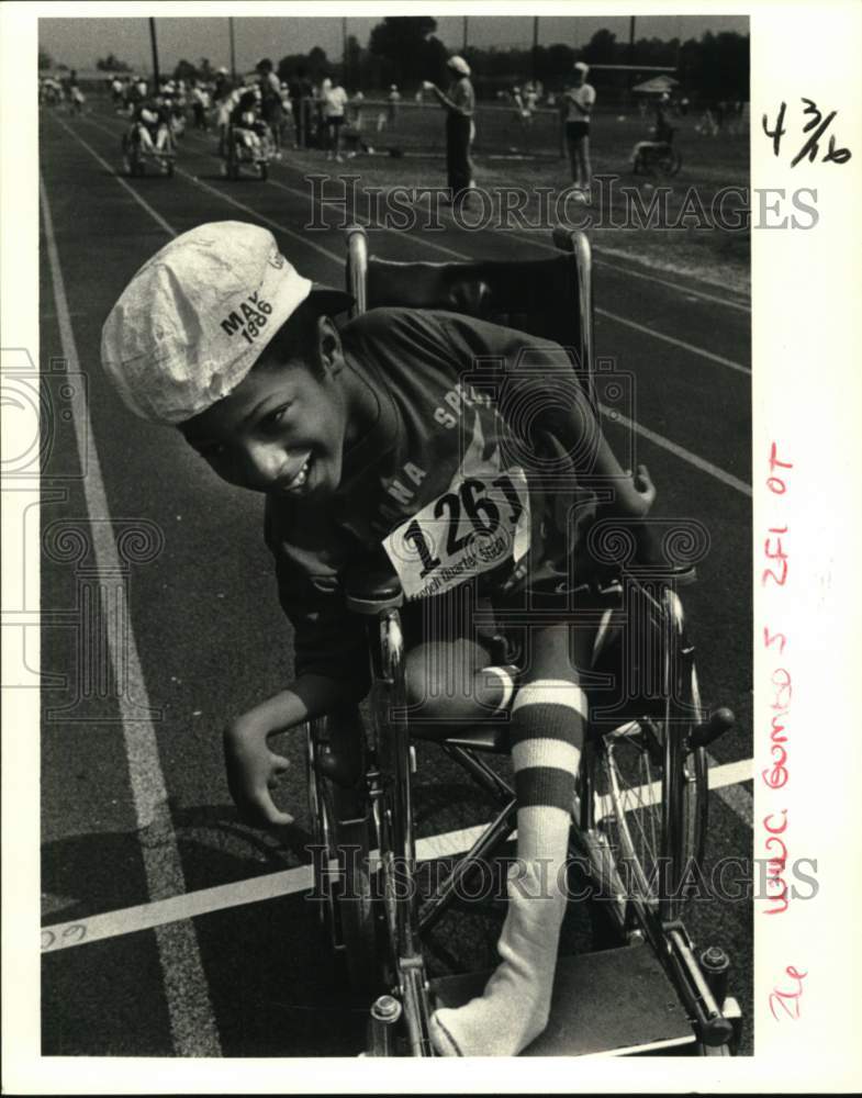 1986 Press Photo Kajain Cranson rolls over the finish line in his wheelchair.- Historic Images