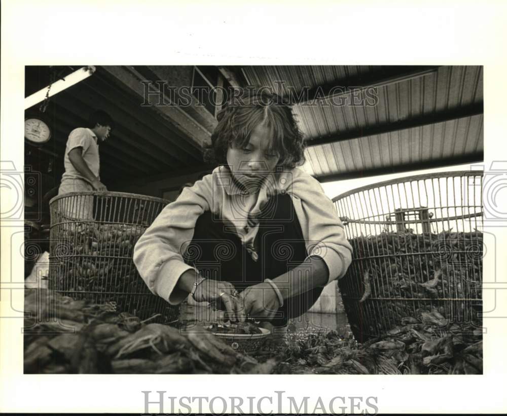 1987 Press Photo Phon Tran takes heads off shrimp on dock of Fulton Seafood Co.- Historic Images