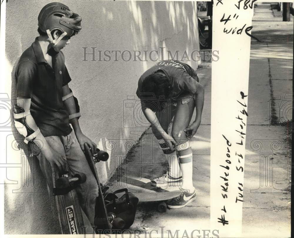 1977 Press Photo Padded and protected skateboarder Michael Martin tends scrape.- Historic Images