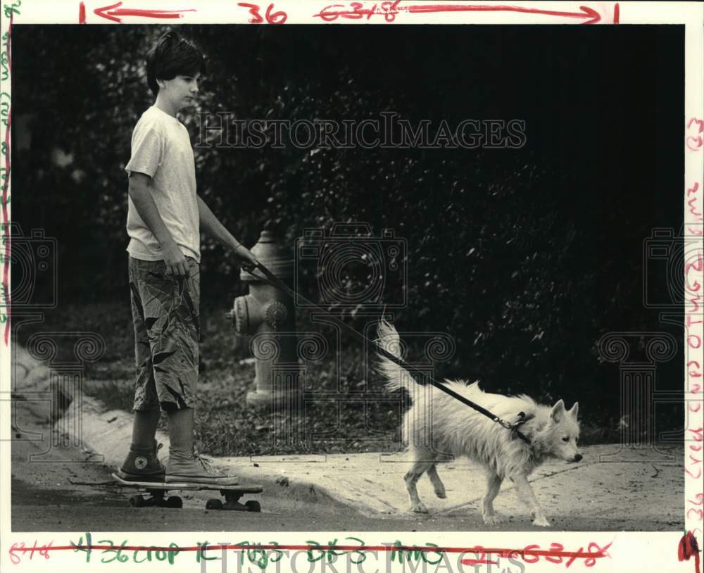 1986 Press Photo Tony White strolls with his dog Freja on his skateboard- Historic Images