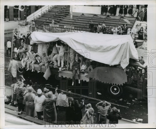  Press Photo Carnival Parade- Float riders covered in plastic as very few watch.- Historic Images