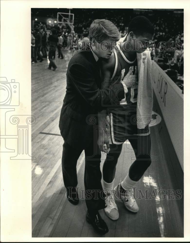 1986 Press Photo assists his player after basketball game- Historic Images