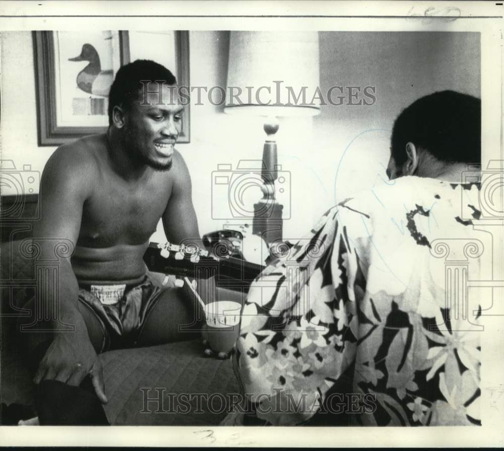 1970 Press Photo Boxer Joe Frazier sings while another man plays the guitar- Historic Images