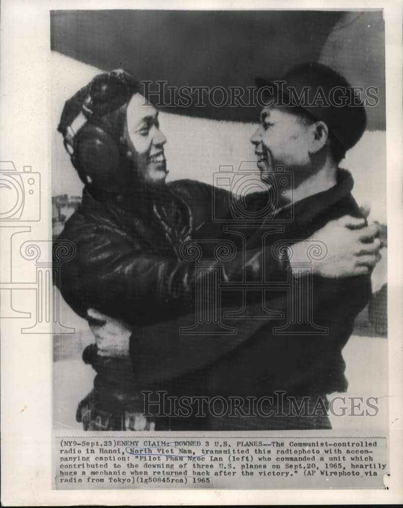 Load image into Gallery viewer, 1965 Press Photo North Vietnamese Pilot Pham Ngoc Lan Hugs Mechanic after Flight
