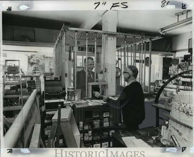 Load image into Gallery viewer, 1975 Press Photo Sidney Brewer serves through bars at hardware store in Gentilly
