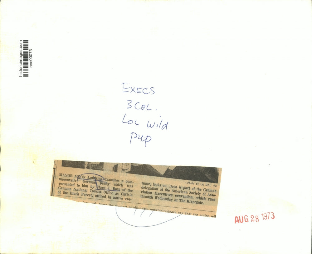 1973 Press Photo Mayor Moon Landrieu examines German penny given by Claus Born