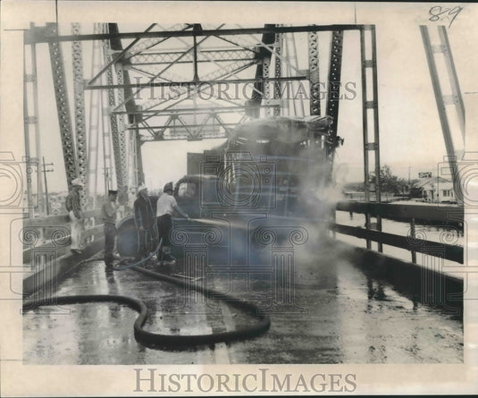 1957 Press Photo Firemen put out a blaze after a truck crashed into Chef bridge