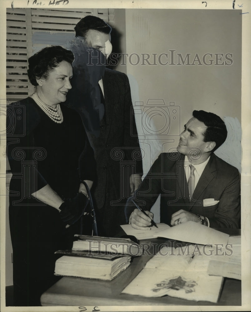 1960 Press Photo Mrs.Esperanza De la Villesbret looks on as her son signs papers