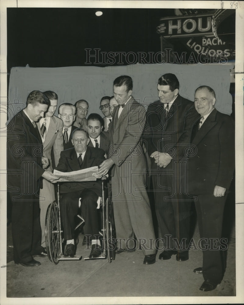 1952 Press Photo Commissioner Moore reads news paper under new lights