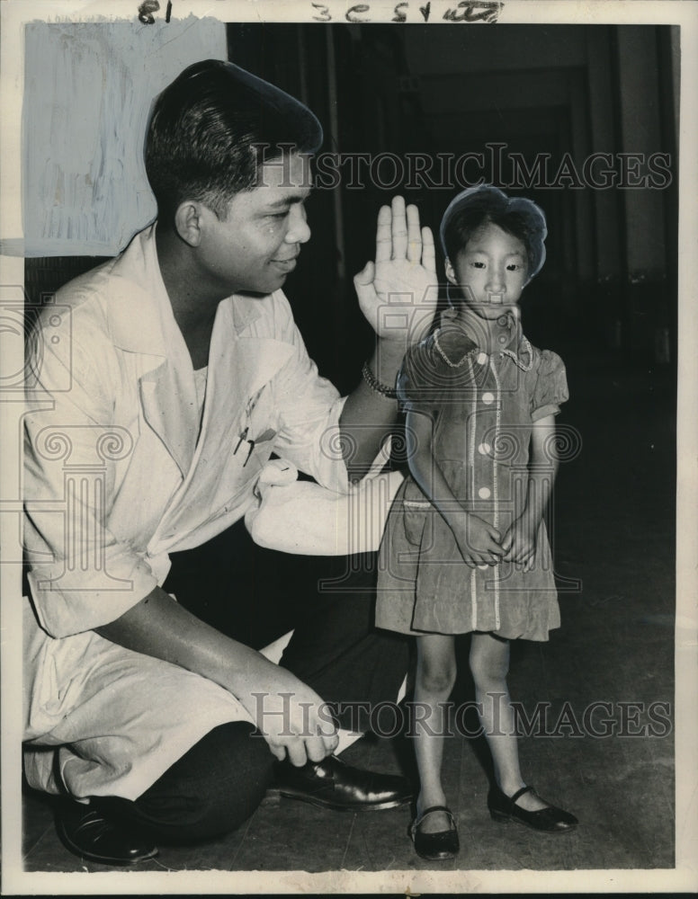 Load image into Gallery viewer, 1960 Press Photo Dr. Hwang Pa-Yee examines tiny girl from Taipei, Formosa
