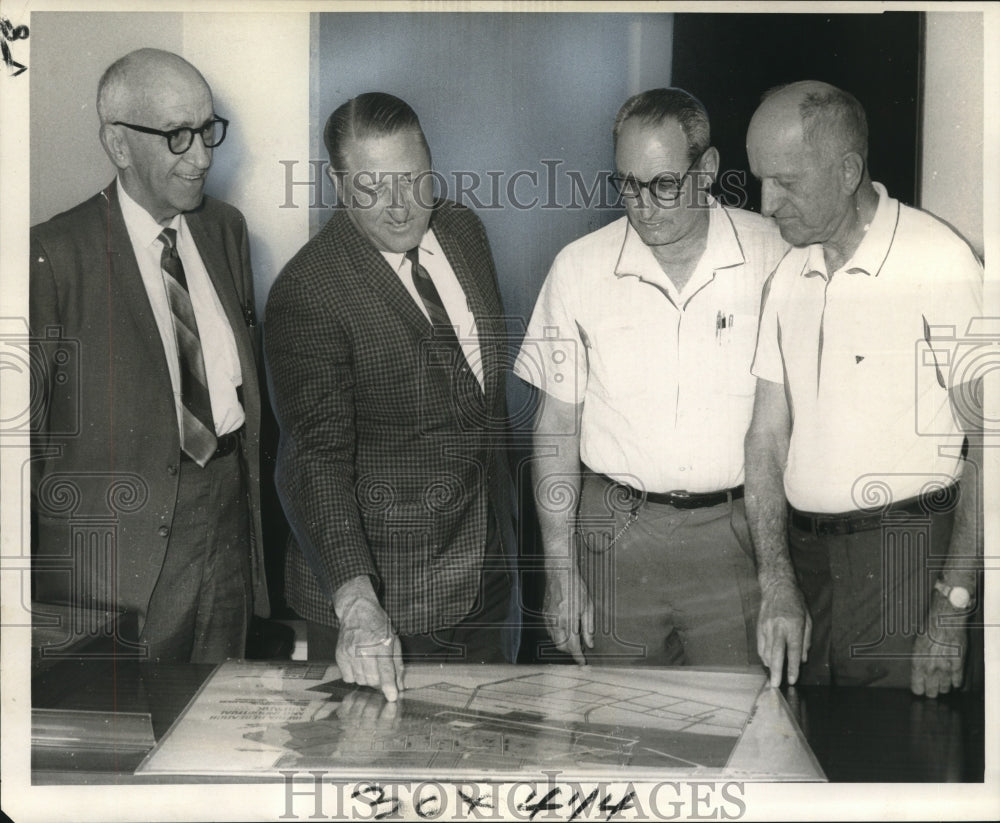 1969 Press Photo GSRI members look over a map of the base where they operate.