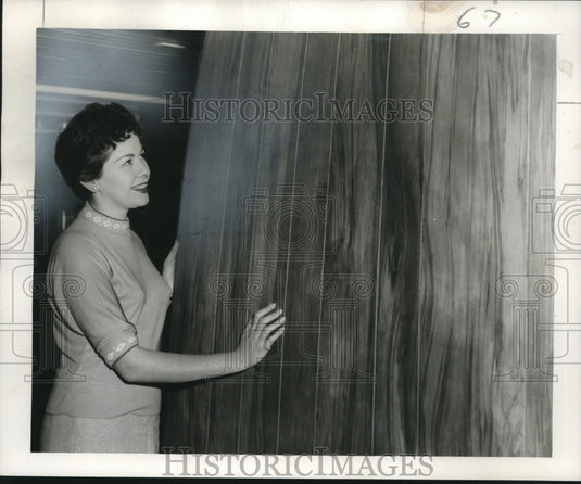1956 Press Photo Gerrie Faia examines a wood paneling at the Fine Woods Company