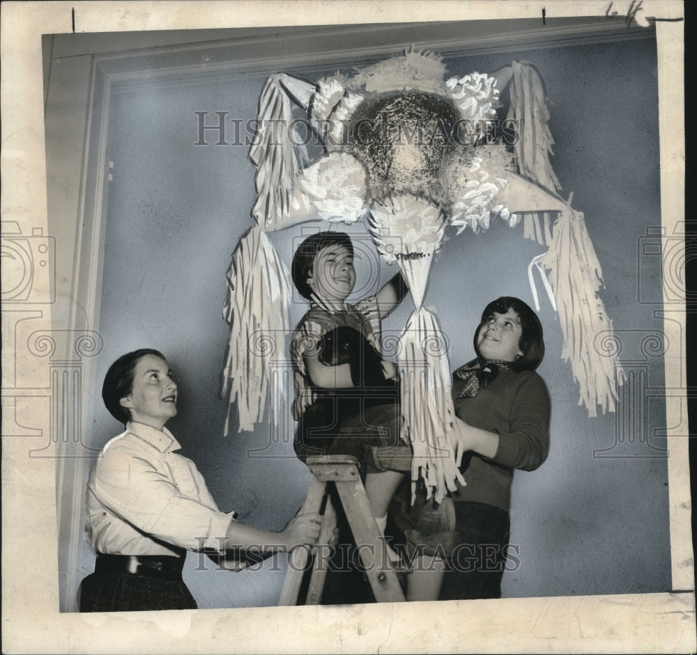 1955 Press Photo Terry Fletterich &amp; Daughters Hang Christmas Pinata - noo19759