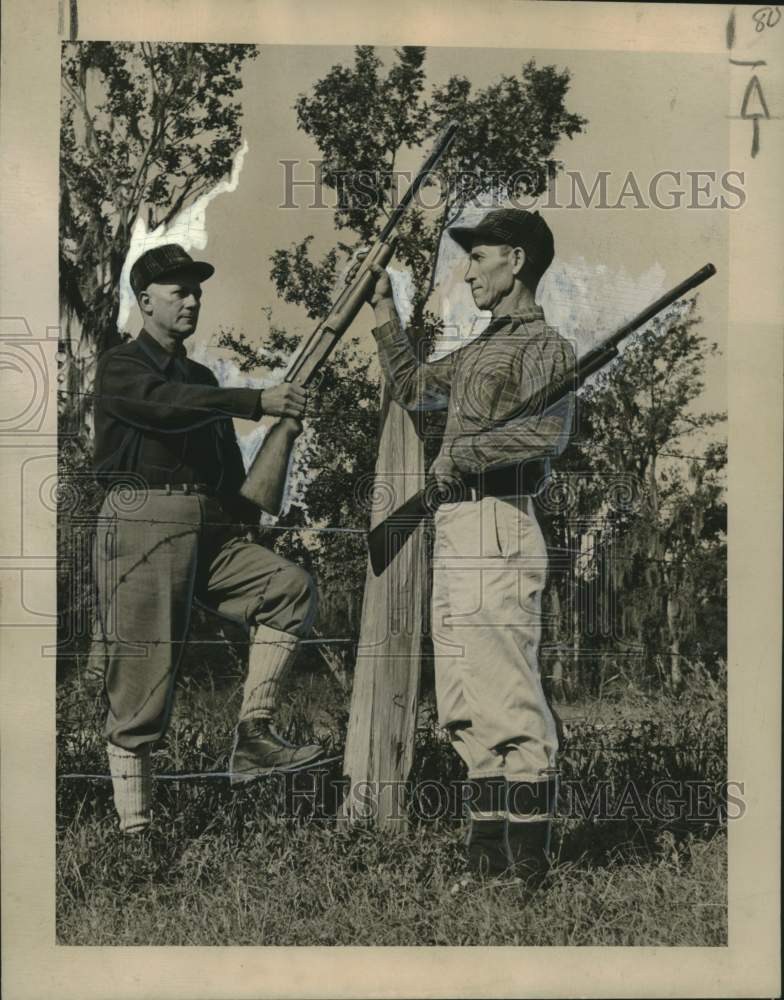 Load image into Gallery viewer, 1949 Press Photo hunters cross fence using guns safely - noo31022
