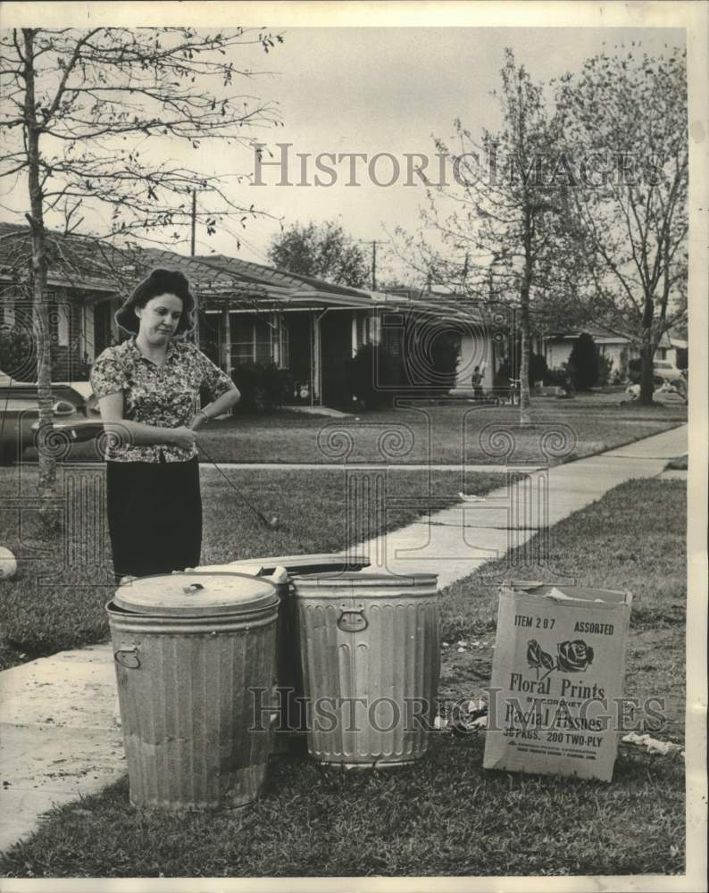 1964 Press Photo Mrs. John Forbes looking at uncollected trash- Bissonet Plaza